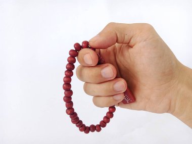 İnsanların elinde tutulan ahşap dua boncuklarının yakın plan görüntüsü, beyaz arka planda bir Müslüman ibadet aracı, İslam dini,