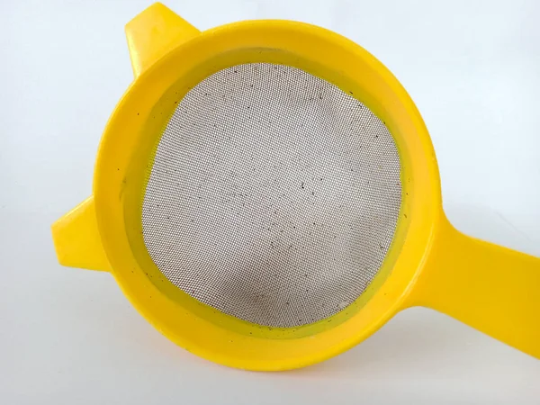 Sarı plastik süzgeç beyaz arka planda izole edilmiş. yakın plan fotoğraf