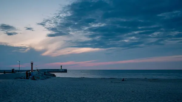 Huzurlu bir sahil kaçışı, koruyucu deniz feneri durgun denizin yanında duruyor..