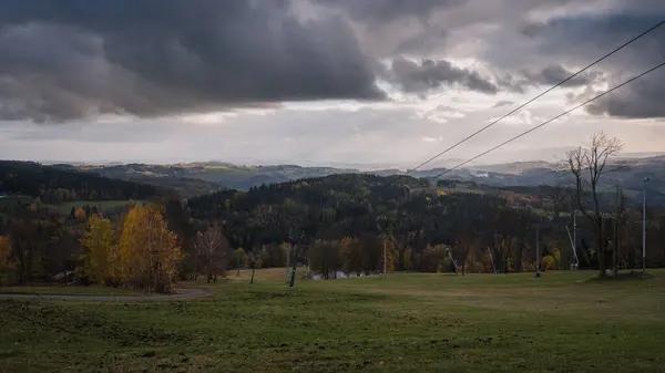 Sonbaharda kar yağmadan önce kayak yamacı ve teleferikli Jizera Dağları manzarası.