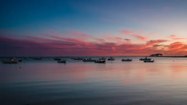 Renkli bir günbatımında yelken açan gemiler