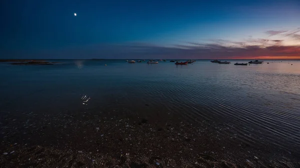 Renkli bir günbatımında yelken açan gemiler