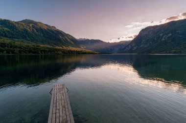 Bohinj Gölü 'nün üzerinde iskele ile gün batımı