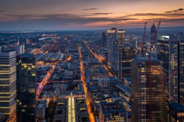 Frankfurt am Main 'in merkezinin akşam manzarası. Gökdelenleri ve caddeleri aydınlık.