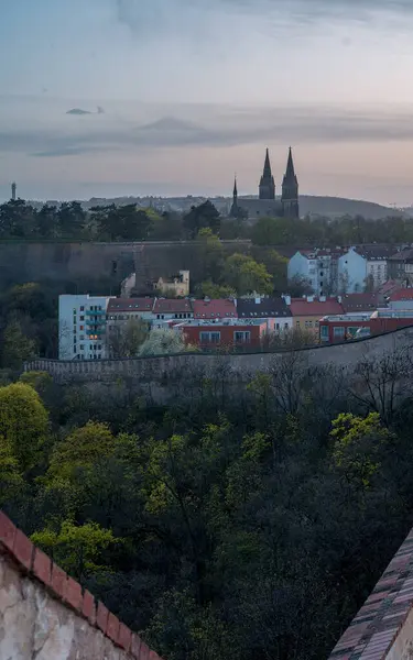 Bu görüntü Nusle Köprüsü 'nden, uzaktaki Vyehrad Katedrali' nin huzurlu günbatımı görüntüsünü yakalar. Hava, Sahra tozu parçacıklarından gelen eşsiz bir parıltıyla dolu. Prag siluetine mistik bir nitelik katıyor..