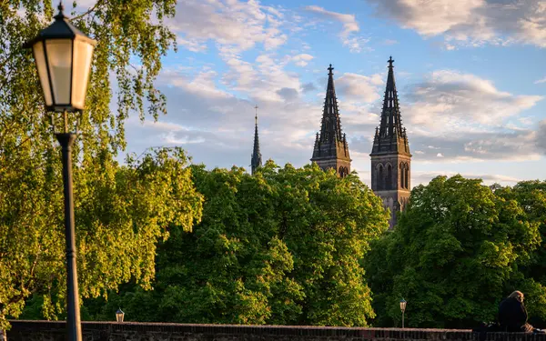 Prag 'daki Vysehrad' daki Gotik Katedrali, ilkbahar akşamı, ön planda güneş ve lamba..