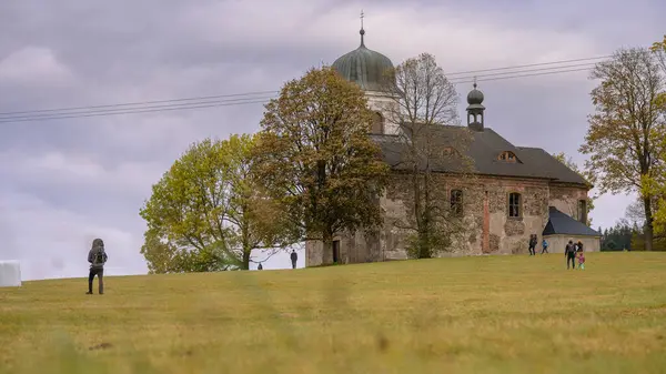 Çek Cumhuriyeti 'ndeki Kartal Dağları' ndaki St. Matthew Kilisesi, sonbahar havası, etrafta koşuşturan ve sonbaharın tadını çıkaran insanlar..