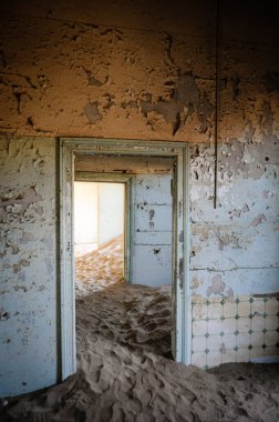 Kayıp bir yerin içinde, kumla dolu bir hayalet ev. 