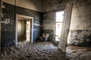 Kayıp bir yerin içinde, kumla dolu bir hayalet ev. 