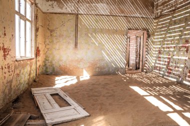 Kayıp bir yerin içinde, kumla dolu bir hayalet ev. 