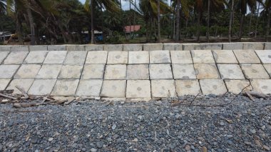 Dalga kırıcılar sahilde, betondan yapılmış düzgün düzenlenmiş küpler şeklinde dizilmiştir.