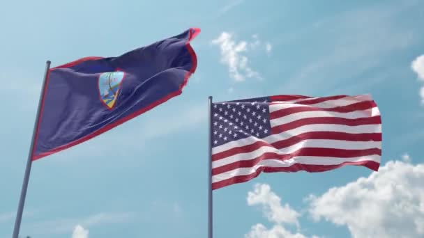 グアムの旗とアメリカの旗は スクリーンセーバーやイントロとして青空の強い風に現実的な波の上にあります グアムとアメリカ合衆国の領土 — ストック動画