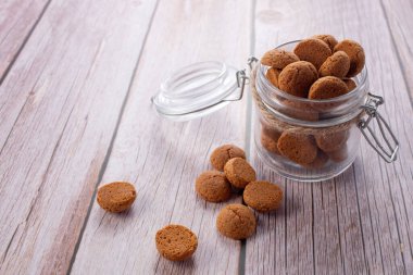 Pepernoten kurabiyeleri cam kavanozda çuval bezin üzerinde. Aziz Niklas Günü için geleneksel tatlılar.