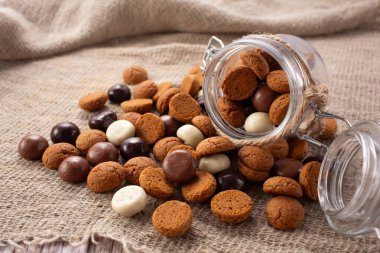 Pepernoten kurabiyeleri cam kavanozda çuval bezin üzerinde. Aziz Niklas Günü için geleneksel tatlılar.