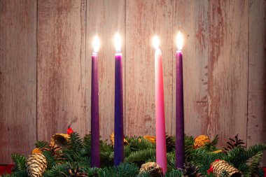 Fourth advent with three burning candles on fir branches with Christmas decoration. clipart