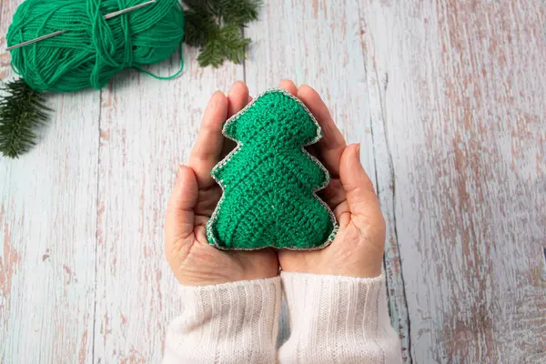Kadın ellerine Noel ağacı ördüm. Yakın plan. El yapımı Noel hediyeleri.