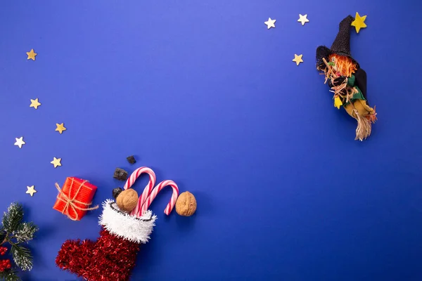 Epifani günü geleneği. Befana ve kırmızı çorap. Koyu mavi arka planda tatlı kömür ve şeker..
