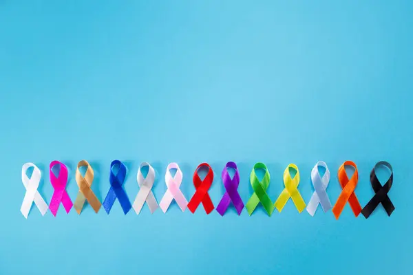 4 Şubat Dünya Kanseri Günü. Renkli farkındalık kurdeleleri Sağlık hizmetleri ve tıbbi konsept.