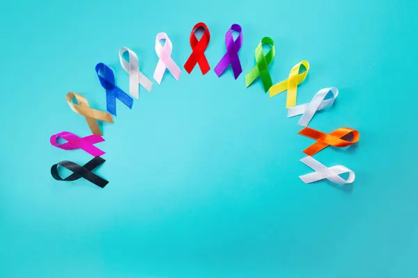 4 Şubat Dünya Kanseri Günü. Renkli farkındalık kurdeleleri Sağlık hizmetleri ve tıbbi konsept.