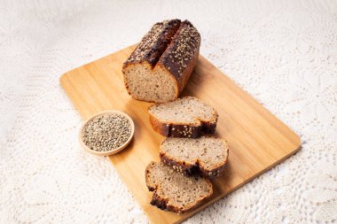 Kenevir tohumlu ve hecelenmiş taze ekşi somun ekmek keten havlunun üzerinde. Sağlıklı pasta..