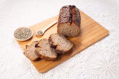 Kenevir tohumlu ve hecelenmiş taze ekşi somun ekmek keten havlunun üzerinde. Sağlıklı pasta..