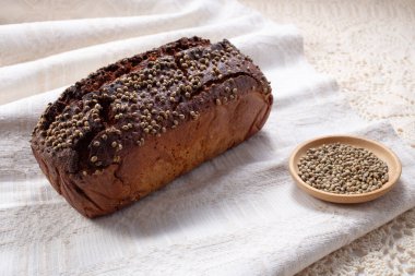 Kenevir tohumlu ve hecelenmiş taze ekşi somun ekmek keten havlunun üzerinde. Sağlıklı pasta..