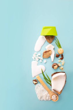Macadamia fındığı, hindistan cevizi, hindistan cevizi unu ve süt mavi arka planda. Ürün tasarımı. Doğal kozmetik malzemeleri. Üst görünüm 