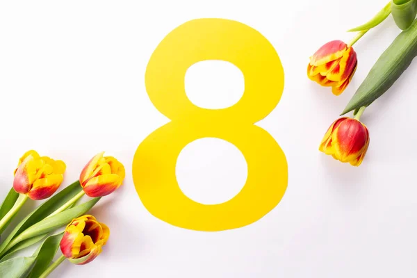 Uluslararası Kadınlar Günü tebrik kartı. 8 Mart konsepti. Lale ve sarı sekiz numara beyaz arkaplanda.. 