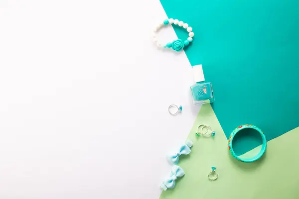 Küçük kız aksesuarları beyaz ve yeşil arka planda, düz yatıyordu.