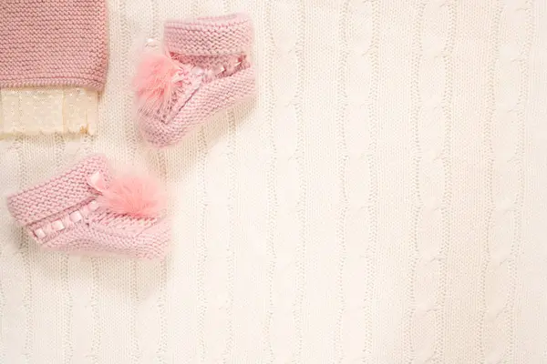 Pembe örülü çoraplar ve beyaz arka planda bir şamata. Uzayı kopyala Bebek doğumu konsepti