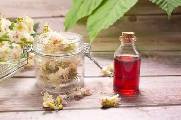 Kestane çiçeği ve kestane çiçeğinin özü ahşap bir arka planda izole edilmiş. Saç dökülmesi konsepti.