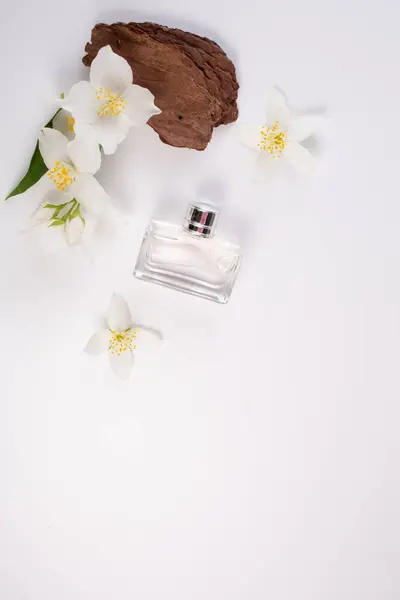 Yasemin çiçekleri ve beyaz arka planda parfüm şişesi. Düz yatıyordu. Uzayı kopyala Yüksek kalite fotoğraf