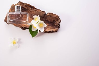 Yasemin çiçekleri, kabuk ve parfüm şişesi beyaz arka planda. Düz yatıyordu. Uzayı kopyala Yüksek kalite fotoğraf