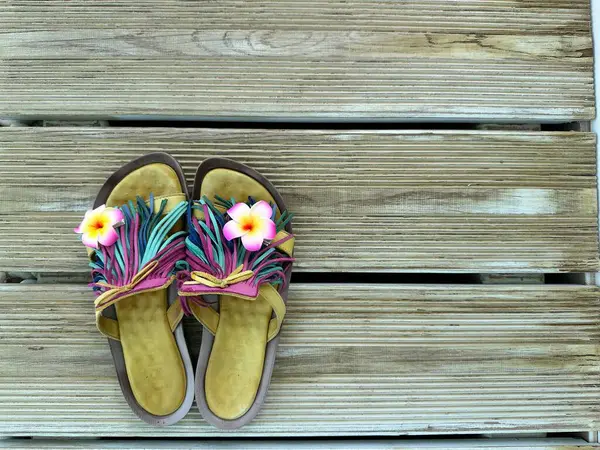 Tahta arka planda parmak arası terlikler. Düz yatıyordu. Yaz tatili konsepti. Yüksek kalite fotoğraf