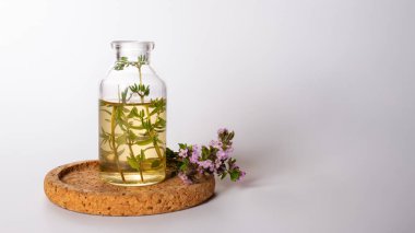 Taze kekik, temel yağ ve beyaz arka planda izole edilmiş ahşap plaka. Saç tedavisi konsepti. Kapat.