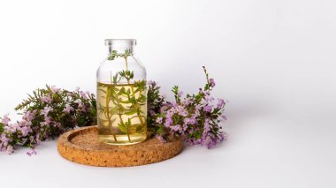 Taze kekik, temel yağ ve beyaz arka planda izole edilmiş ahşap plaka. Saç tedavisi konsepti. Kapat.