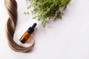 Taze kekik, beyaz arka planda izole edilmiş gerekli yağ ve saç. Saç tedavisi konsepti. Düz yatıyordu.