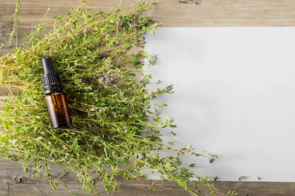 Taze kekik ve ahşap arka planda gerekli yağ. Saç tedavisi konsepti. Uzayı kopyala Düz yatıyordu.