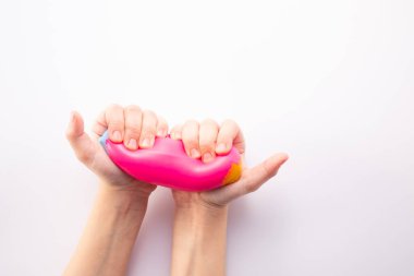 Beyaz arka planda elle sıkılmış pembe stres topu. Pozitif düşünce konsepti. Yüksek kalite fotoğraf