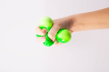 Çocuk eli, beyaz arka planda yeşil stres topunu sıkıyor. Pozitif düşünce konsepti. Yüksek kalite fotoğraf