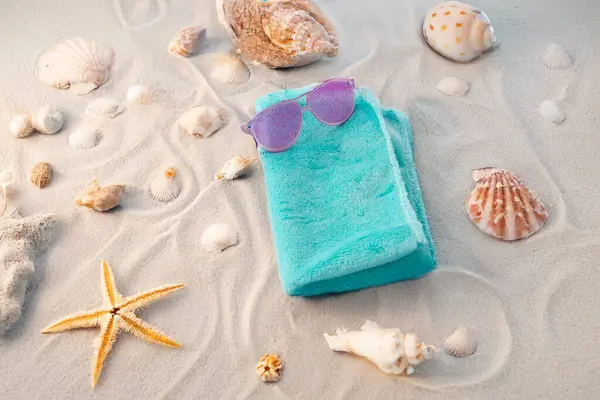 Deniz kabukları, deniz yıldızı ve kumdaki güneş gözlükleri. Düz konum, kopyalama alanı. Tatil konsepti. Yüksek kalite fotoğraf
