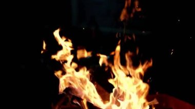 Close-up, flames from fire. Night bonfire, logs are on fire, sparks fly. 4k Super slow motion of flames.