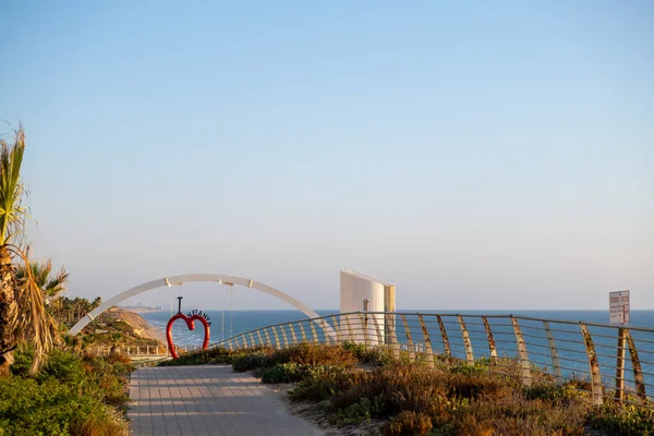 12 Temmuz 2023. İsrail, Netanya. Gün batımında Netanya şehrinin seddi, Netanya 'ya giden yol. Denize giden bir asansörün arka planında..