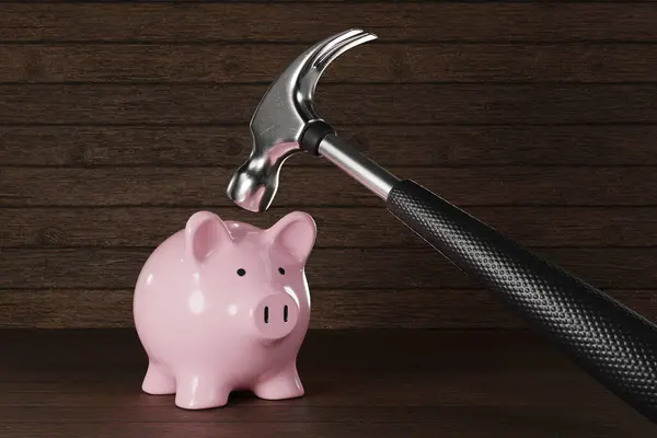 Silver hammer is going to hit on a pink piggy bank in wooden background. Illustration of the concept of bankruptcy, financial crisis, inflation and recession