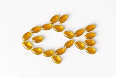 Turuncu sarı balık yağı yumuşak jel kapsülleri beyaz arka planda bir balık şekli oluşturuyor. Omega-3 konsepti, vitaminler ve besin takviyesi