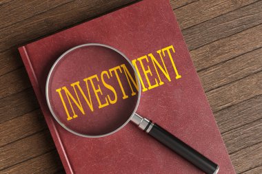 Kırmızı ciltli deri kaplı kitap, tahtadan bir masanın üzerinde altın bir başlık olan INVESTMENT (girintili) ile borçlandı. Borsa ve küresel ticaret kavramının gösterimi