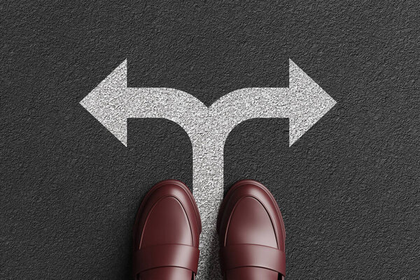 Человек стоит на белом дорожном знаке расщепляющейся стрелы на асфальтовой дороге. Иллюстрация концепции решений и различных карьерных путей