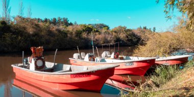 Suda, güneşte üç tekne. Conchillas, Uruguay.