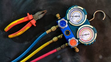 Klima ve havalandırma teknisyenleri için yakın çekim fotoğraf ürünü araçları soğutucuyu kontrol etmek, kaput ve kompresör içindeki bir aracın basıncını kontrol etmek için manilfold göstergesi ile ölçüm.
