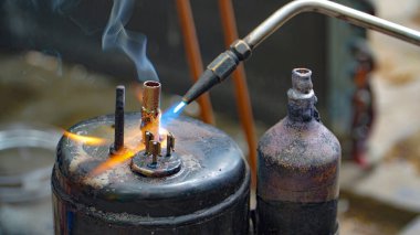 Endüstriyel sistem işçileri bakır boru klima eklemleri ve klima tesisatında bakır tüp büzüşmesi. Klima yoğunlaştırıcı bant sızdırıyor..